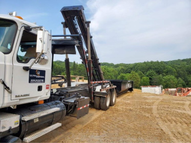 Roll off dumpster getting delivered